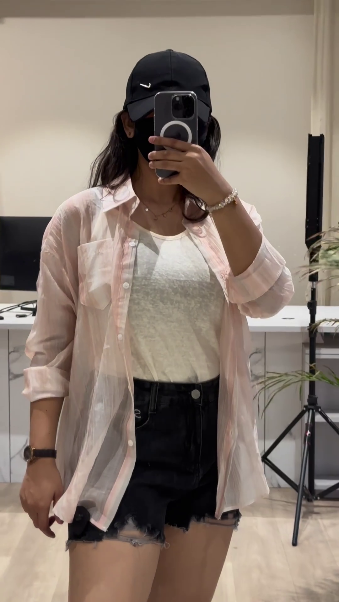 Casual Layered Outfit: Pink Button-Down Shirt, Tank Top, and Denim Shorts