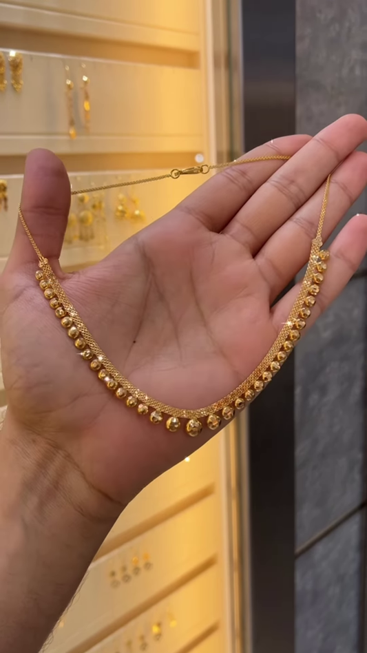 Elegant Gold-Toned Necklace with Spherical Beads and Interwoven Chain Detail